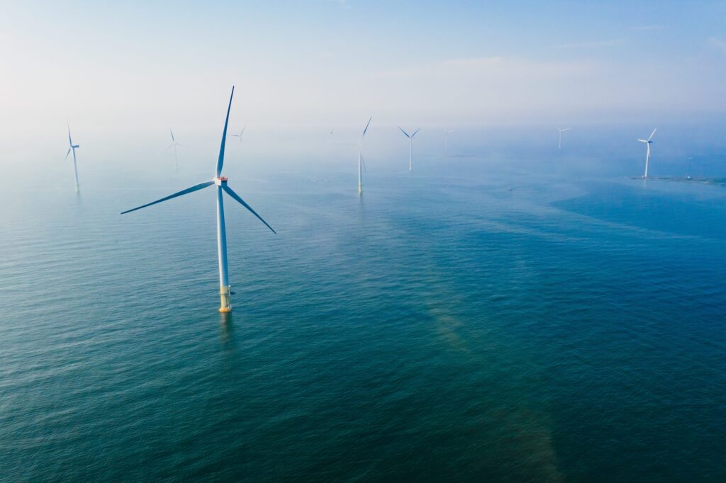 image of a calm ocean with 9 horizontal 3 bladed wind turbines
